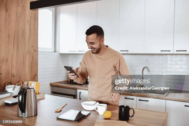 modern male cook comparing his tools to ones used in online recipe on smartphone - stirring stock pictures, royalty-free photos & images