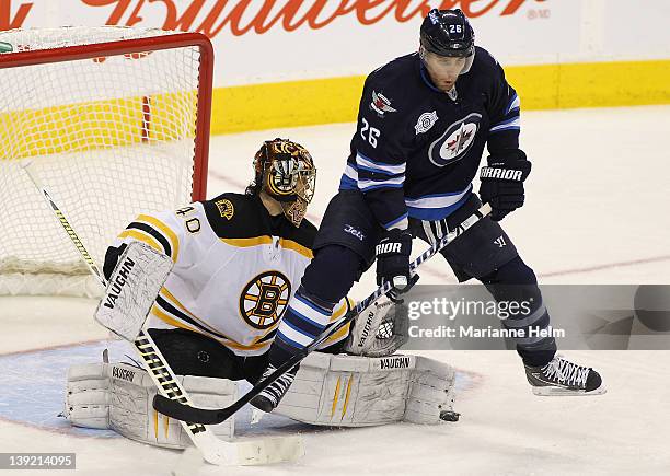 Blake Wheeler of the Winnipeg Jets jumps into the air to miss the puck as Tuukka Rask of the Boston Bruins deflects it in NHL action at the MTS...