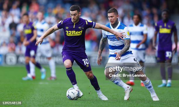 Tom Lawrence of Derby County is marked by Lyndon Dykes of Queens Park Rangers during the Sky Bet Championship match between Queens Park Rangers and...