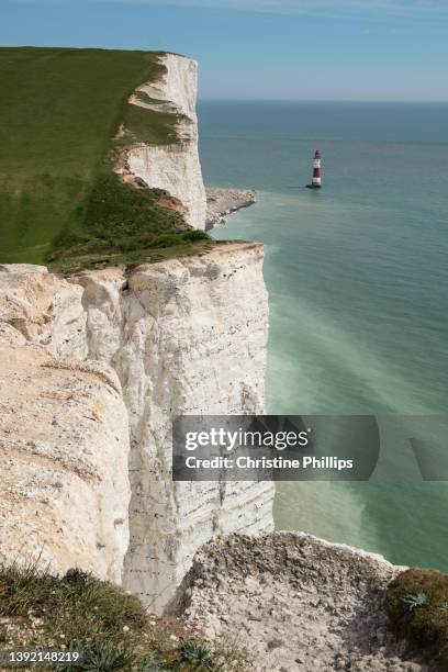 the white cliff, green grass and blue seas of beachy head in the south of england. beachy head lighthouse - beachy head stock pictures, royalty-free photos & images