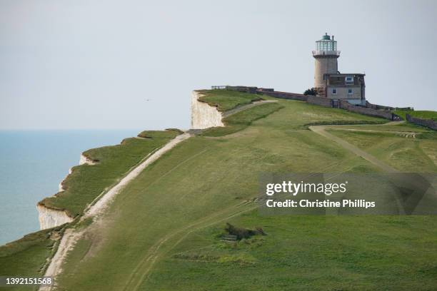 bell tout lighthouse on the the white cliffs, green grass and blue seas of beachy head in the south of england - seven sisters acantilado fotografías e imágenes de stock