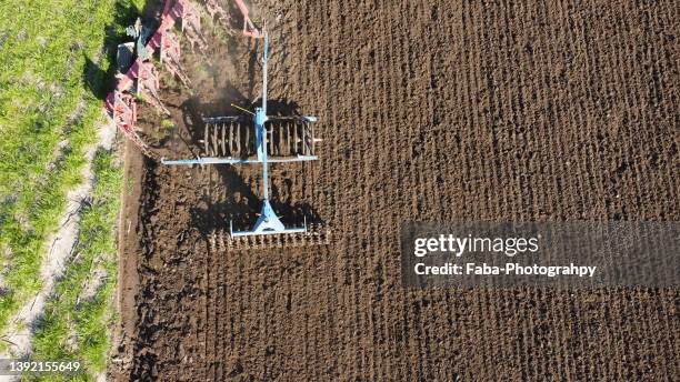 tractor plowing field - harrow agricultural equipment stock pictures, royalty-free photos & images