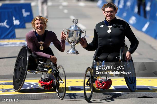 Manuela Schar of Switzerland and Daniel Romanchuk of the United States hold up a trophy after they took first place in the men and womens wheelchair...