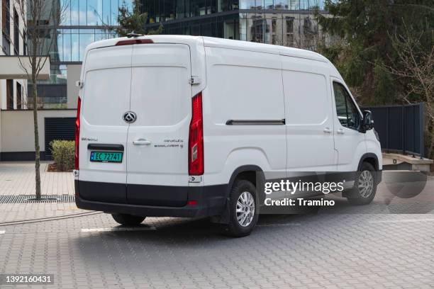 electric delivery van on a street - vehicle manufacturers brand names stock pictures, royalty-free photos & images