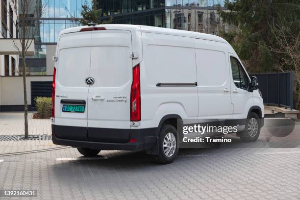 electric delivery van on a street - vehicle manufacturers' brand names imagens e fotografias de stock