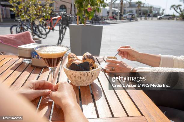 women enjoy continental breakfast at outdoor cafe - personal perspective coffee stock pictures, royalty-free photos & images