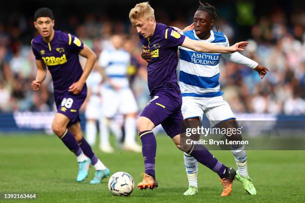 Louie Sibley of Derby County is challenged by Osman Kakay of Queens Park Rangers during the Sky Bet Championship match between Queens Park Rangers...