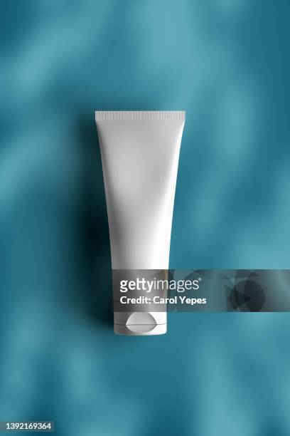 healthcare cosmetics product template in blue backgrouhnd with casting shadows - cosmetic bottle stockfoto's en -beelden