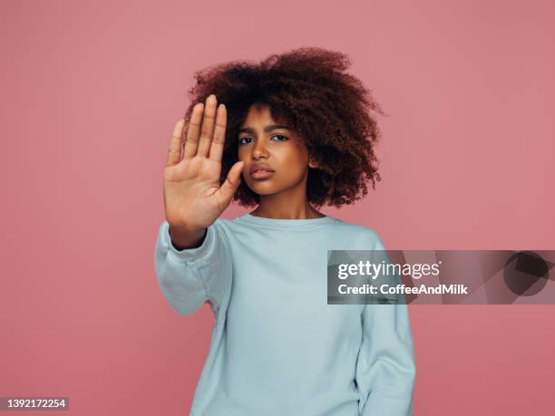 schönes mädchen mit lockiger frisur mit stoppschild - stopschild freisteller stock-fotos und bilder