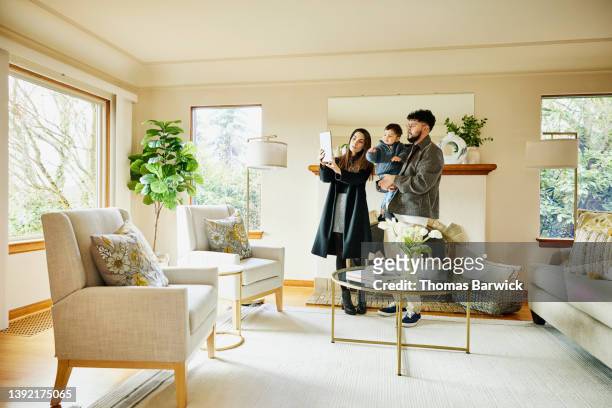 wide shot of family taking picture in living room of home for sale - house viewing stock pictures, royalty-free photos & images