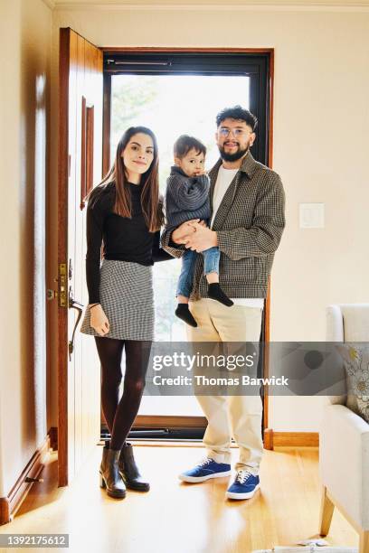 wide shot portrait of family standing by front door of home - open day 3 fotografías e imágenes de stock