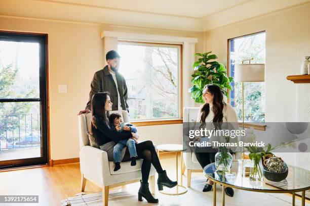 wide shot of family discussing home for sale with real estate agent - premium access image only stock-fotos und bilder