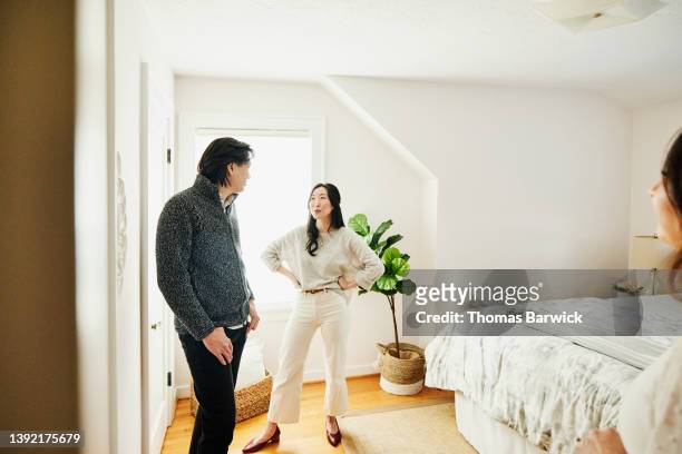 medium wide shot of couple in bedroom of home for sale - chance encounter stock pictures, royalty-free photos & images
