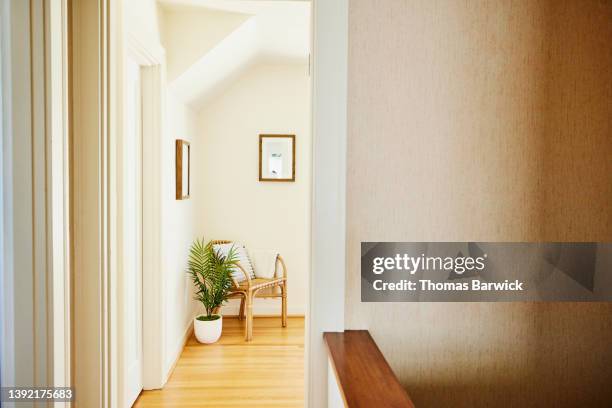 wide shot of hallway and chair in corner of upstairs bedroom in home - korridor stock-fotos und bilder