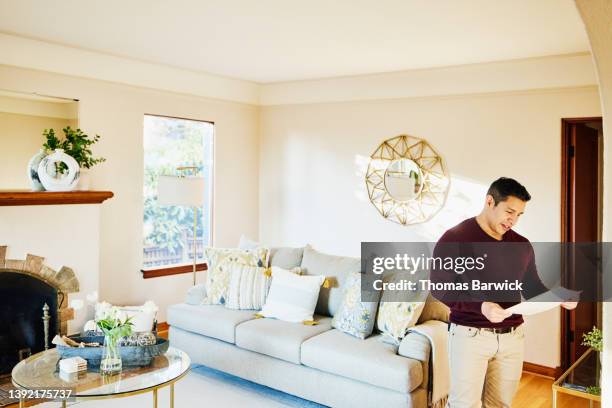 medium wide shot of man looking at sales sheet in home for sale - coffee table front view stock pictures, royalty-free photos & images