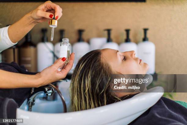 donna che si lava i capelli nel parrucchiere - hairdresser foto e immagini stock