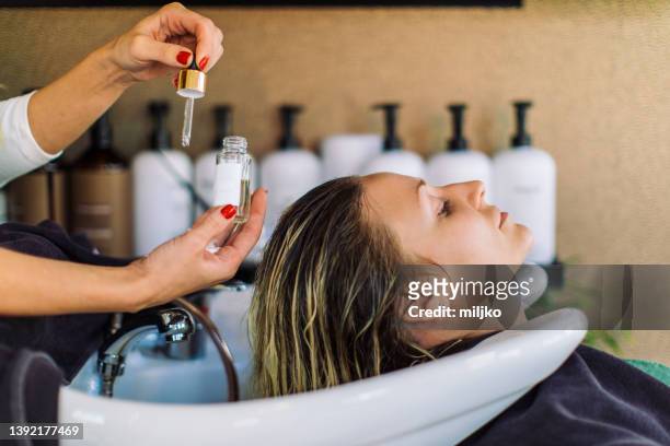 woman getting her hair washed in hair salon - human hair stock pictures, royalty-free photos & images