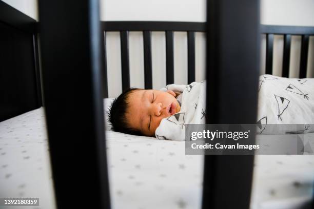 newborn baby sleeps soundly in his crib - baby blanket stock pictures, royalty-free photos & images