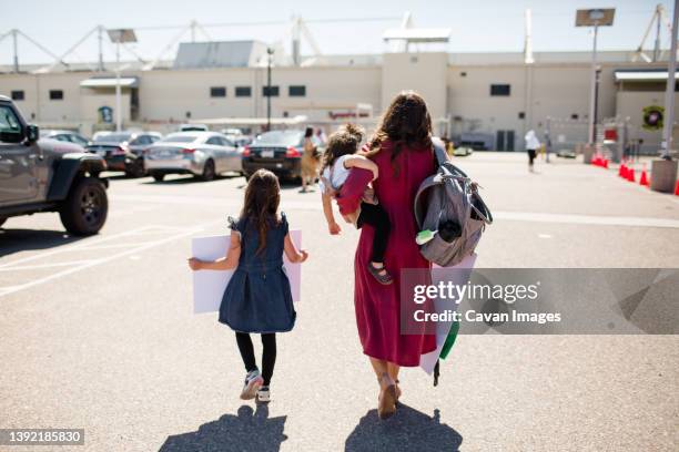 mother & two daughters walking onto base for military homecoming - military wife stock pictures, royalty-free photos & images