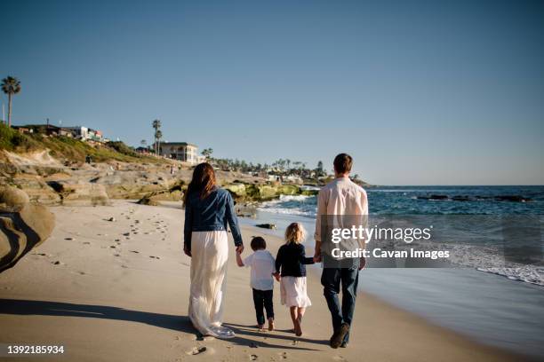 family of four walking on beach in san diego - san diego california beach stock pictures, royalty-free photos & images
