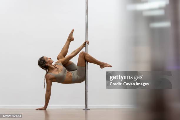 woman dancing choreographed on the pole dance school sport dance - pole dance fotografías e imágenes de stock