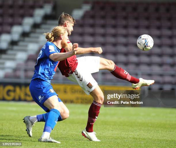 Jon Guthrie of Northampton Town clears the ball from Luke Armstrong of Harrogate Town during the Sky Bet League Two match between Northampton Town...