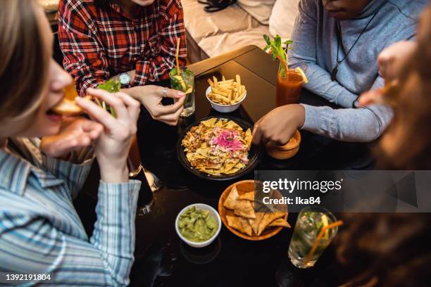 grupo de jovens gostando de comer nachos e beber coquetéis - nachos - fotografias e filmes do acervo