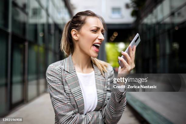 mujer de negocios enojada usando gritos de teléfono - mujeres de mediana edad fotografías e imágenes de stock