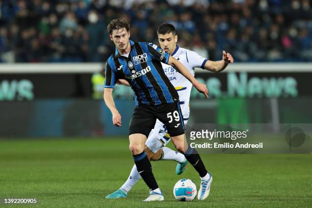 Aleksey Miranchuk of Atalanta is challenged by Miguel Veloso of Hellas Verona during the Serie A match between Atalanta BC and Hellas Verona FC at...