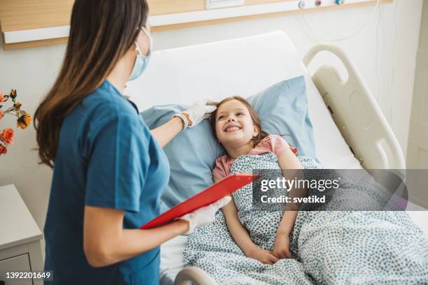 kleines mädchen im krankenhausbett - pediatric nurse stock-fotos und bilder