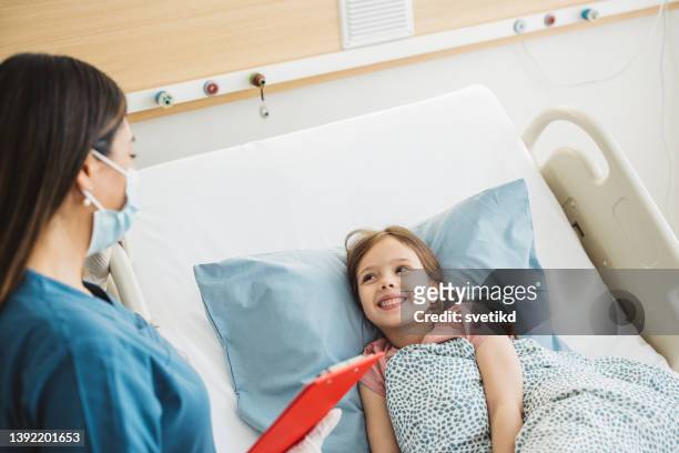 病院のベッドで小さな女の子 - 風邪マスク ストックフォトと画像
