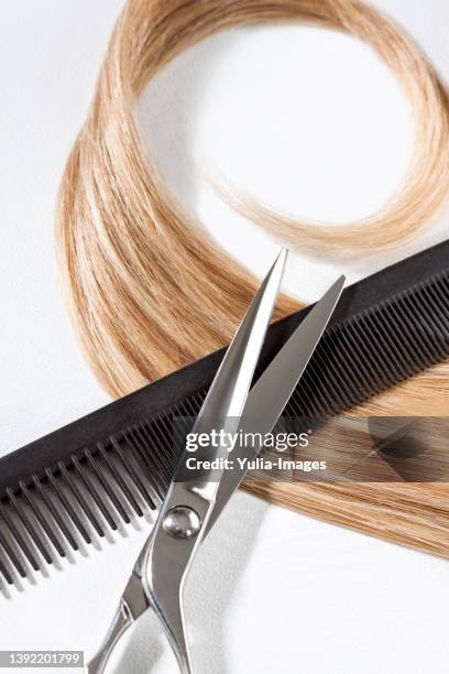 blond hair with comb and scissors - hair coils stockfoto's en -beelden