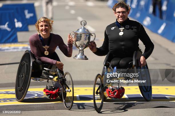 Manuela Schar of Switzerland and Daniel Romanchuk of the United States hold up a trophy after they took first place in the men and womens wheelchair...