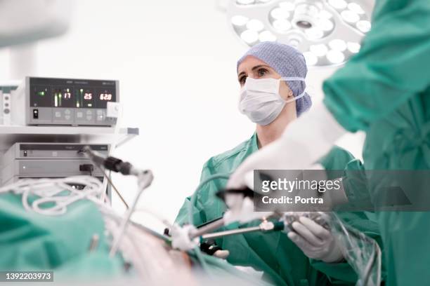 woman surgeon performing gastric bypass surgery - laparoscopy stockfoto's en -beelden