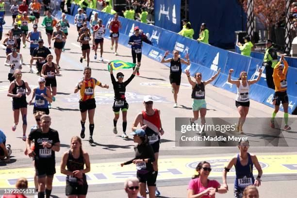 Runners cross the finish line during the 126th Boston Marathon on April 18, 2022 in Boston, Massachusetts.