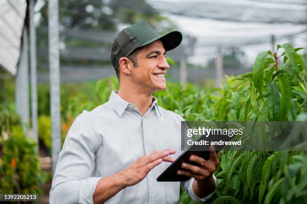 brasilianischer mann, der technologie im feld arbeitet und einsetzt - business man smartphone tablet stock-fotos und bilder