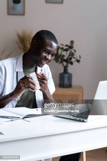 african american doctor consults the contraindications of a drug with a patient in a video call - telemedicine choicepix stock pictures, royalty-free photos & images