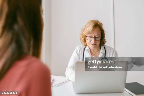 doctor attending to a patient in her medical office. - gynaecologist stock pictures, royalty-free photos & images