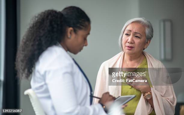senior patient complaining of chest pain - chest pain stock pictures, royalty-free photos & images