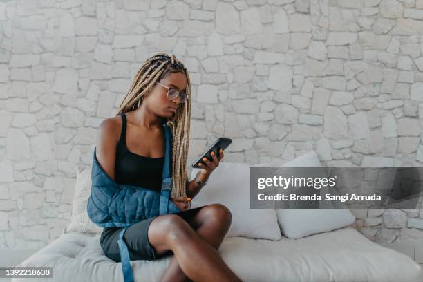 junge frau mit immobilisiertem rechtem arm - armbruch stock-fotos und bilder