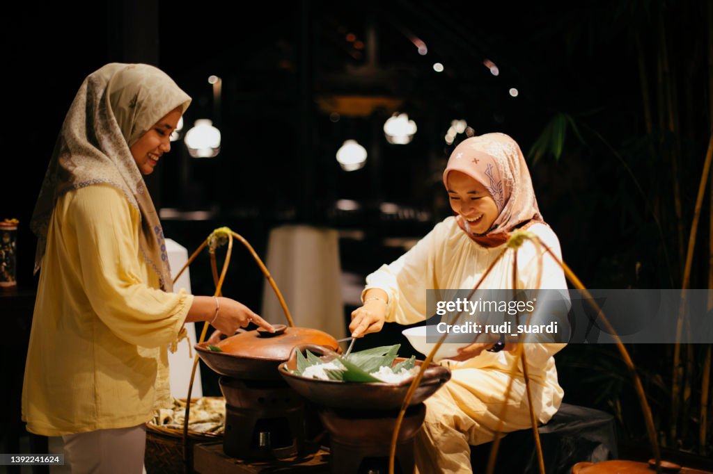 Asian young muslim woman buying nasi uduk in street market in Jakarta