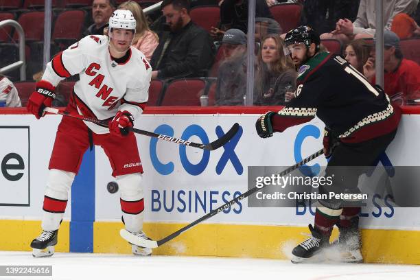 Brendan Smith of the Carolina Hurricanes passes the puck under pressure from Andrew Ladd of the Arizona Coyotes during the first period of the NHL...