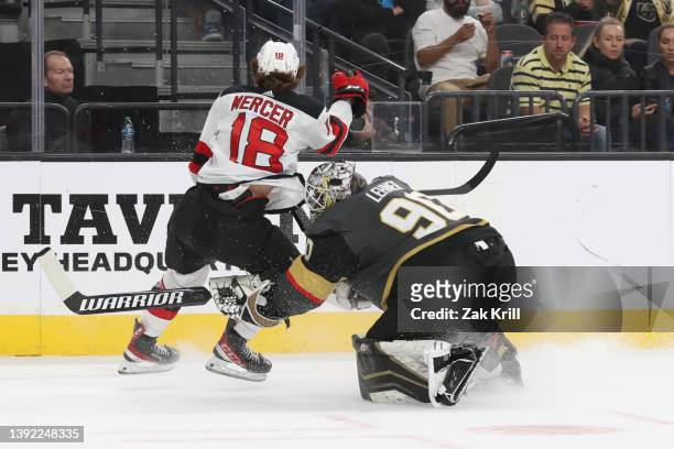 Robin Lehner of the Vegas Golden Knights collides with Dawson Mercer of the New Jersey Devils after clearing the puck during the first period at...
