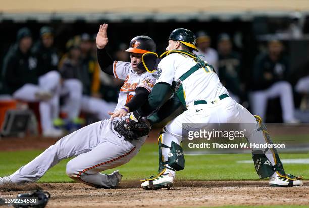 Trey Mancini of the Baltimore Orioles is tagged out at home plate by Sean Murphy of the Oakland Athletics in the top of the seventh inning of the...