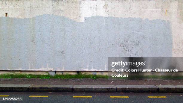 empty painted and weathered wall with dirty and wet sidewalk and street in paris - rain gutter imagens e fotografias de stock