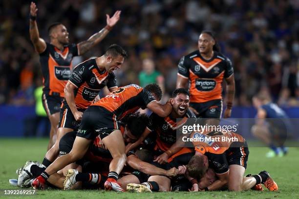 Jackson Hastings of the Tigers celebrates with team mates after kicking a field-goal to win the round six NRL match between the Parramatta Eels and...