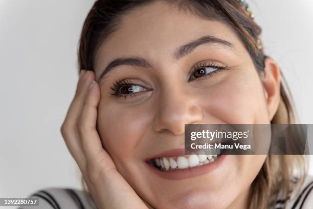 close-up of a happy and smiling young woman looking away - extreme close up face stock pictures, royalty-free photos & images