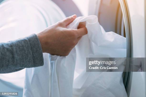 hand loading the washing machine - bedding stock pictures, royalty-free photos & images