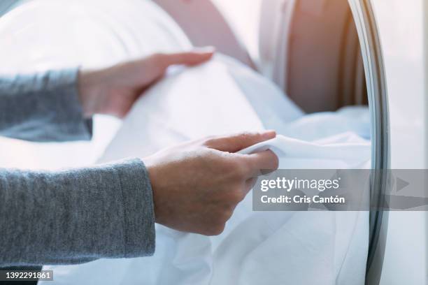 woman unloading the washing machine - bedding foto e immagini stock