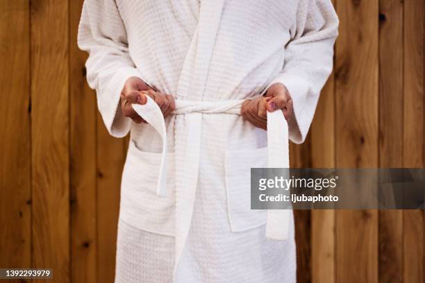 close up on the hands of a man as he is tying the belt of his bathrobe - morgonrock bildbanksfoton och bilder